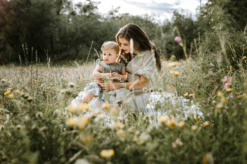 Family Photography, A mother embraces her toddler in a field of flowers